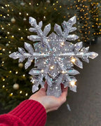 Silver glitter snowflake topper held in hand