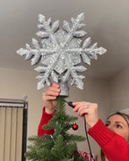 Placing the snowflake topper on the tree